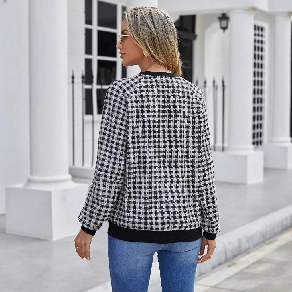 Black and white plaid print long sleeve pullover sweater for men on a neutral background.