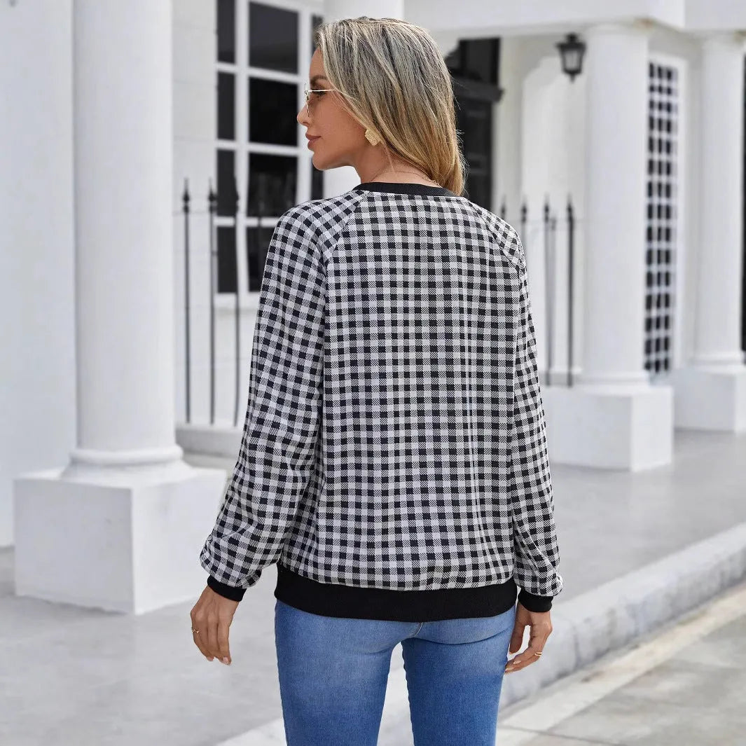 Black and white plaid print long sleeve pullover sweater for men on a neutral background.