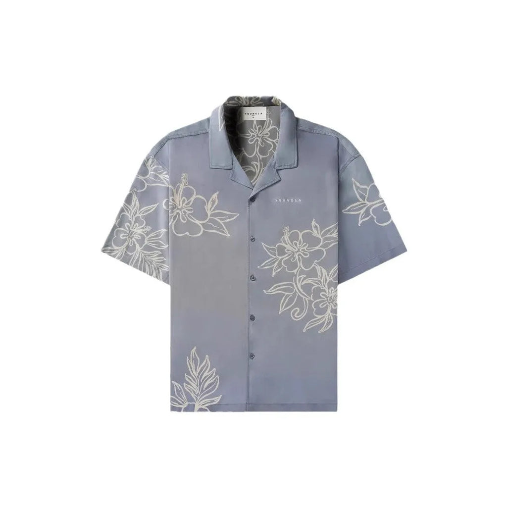 Man wearing a loose, short-sleeved printed floral top in a light colour.