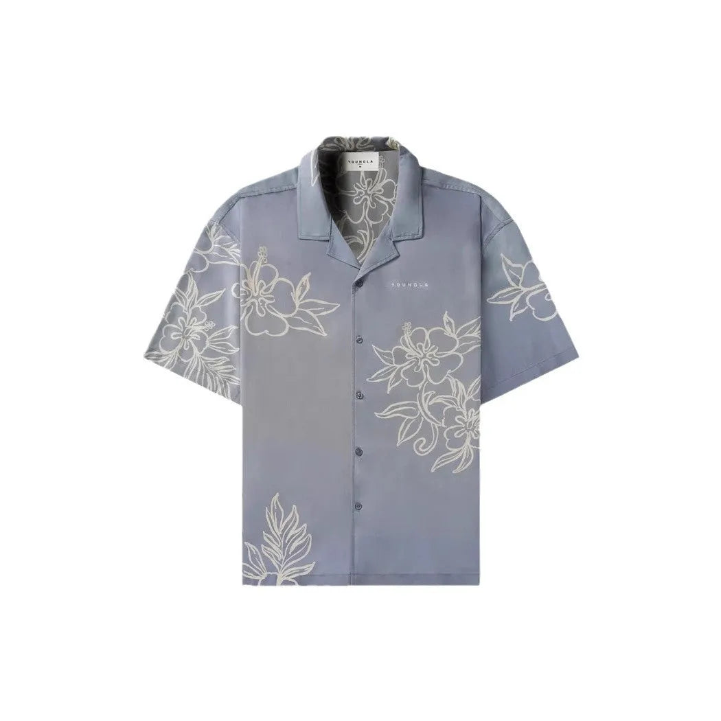 Man wearing a loose, short-sleeved printed floral top in a light colour.