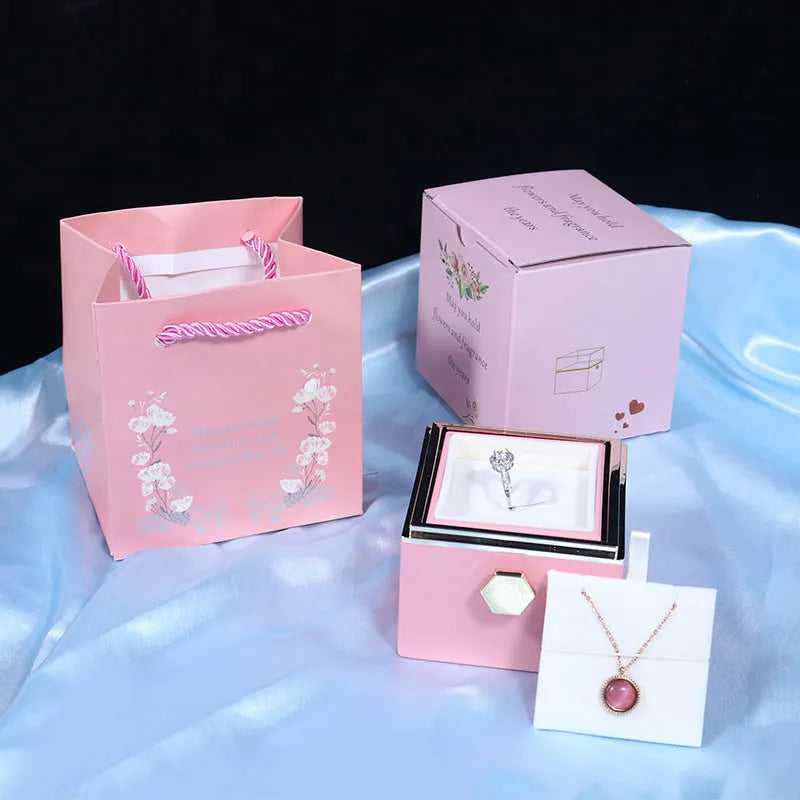 Rotating jewellery gift box with a preserved red rose under a clear acrylic dome.