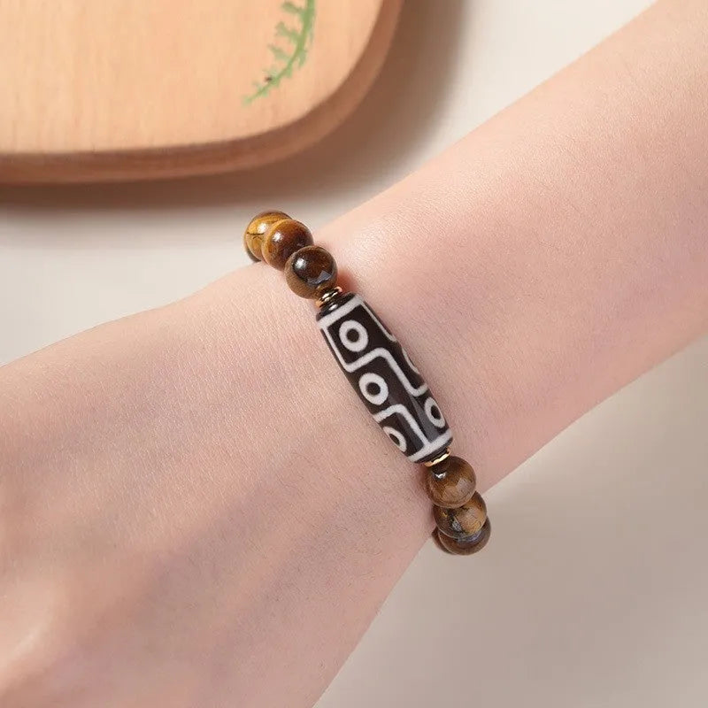 Single strand tigereye Buddha bead bracelet with dzi pattern on wrist, showing 10mm bead size.