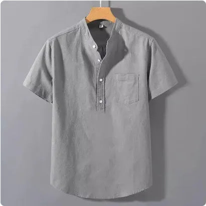 Man wearing a beige loose-fit slub linen casual shirt with a stand collar and short sleeves.