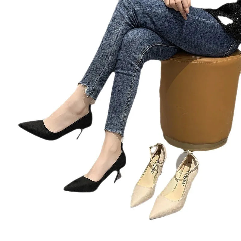 Women's black stiletto heel pump shoe with a skull pattern and buckle detail on a white background.