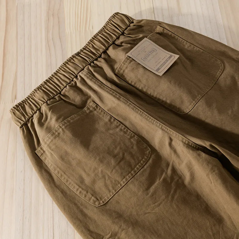 Men's army green cotton overalls with drawstring waist and ankle banded cuffs laid flat