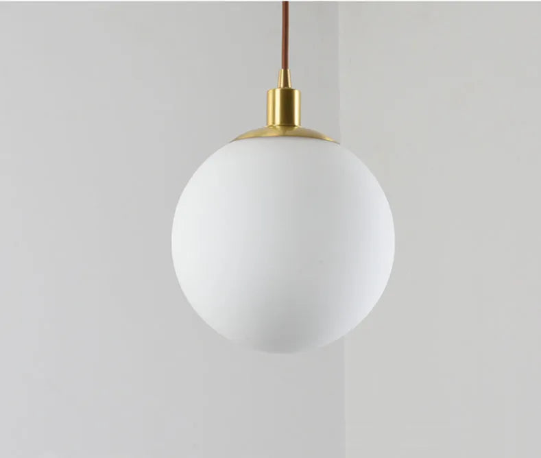 Nordic glass round spherical chandelier in milk white with copper fittings on a light background