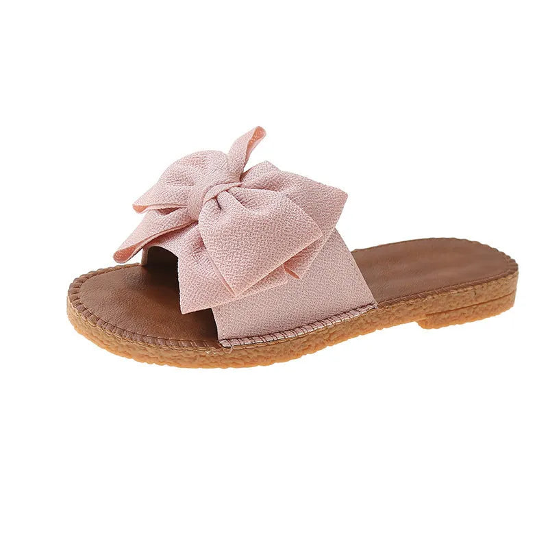 Women's slip-on suede sandals with bow detail in beige, light green, and pink colour options