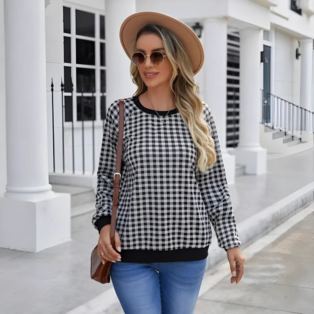 Black and white plaid print long sleeve pullover sweater for men on a neutral background.