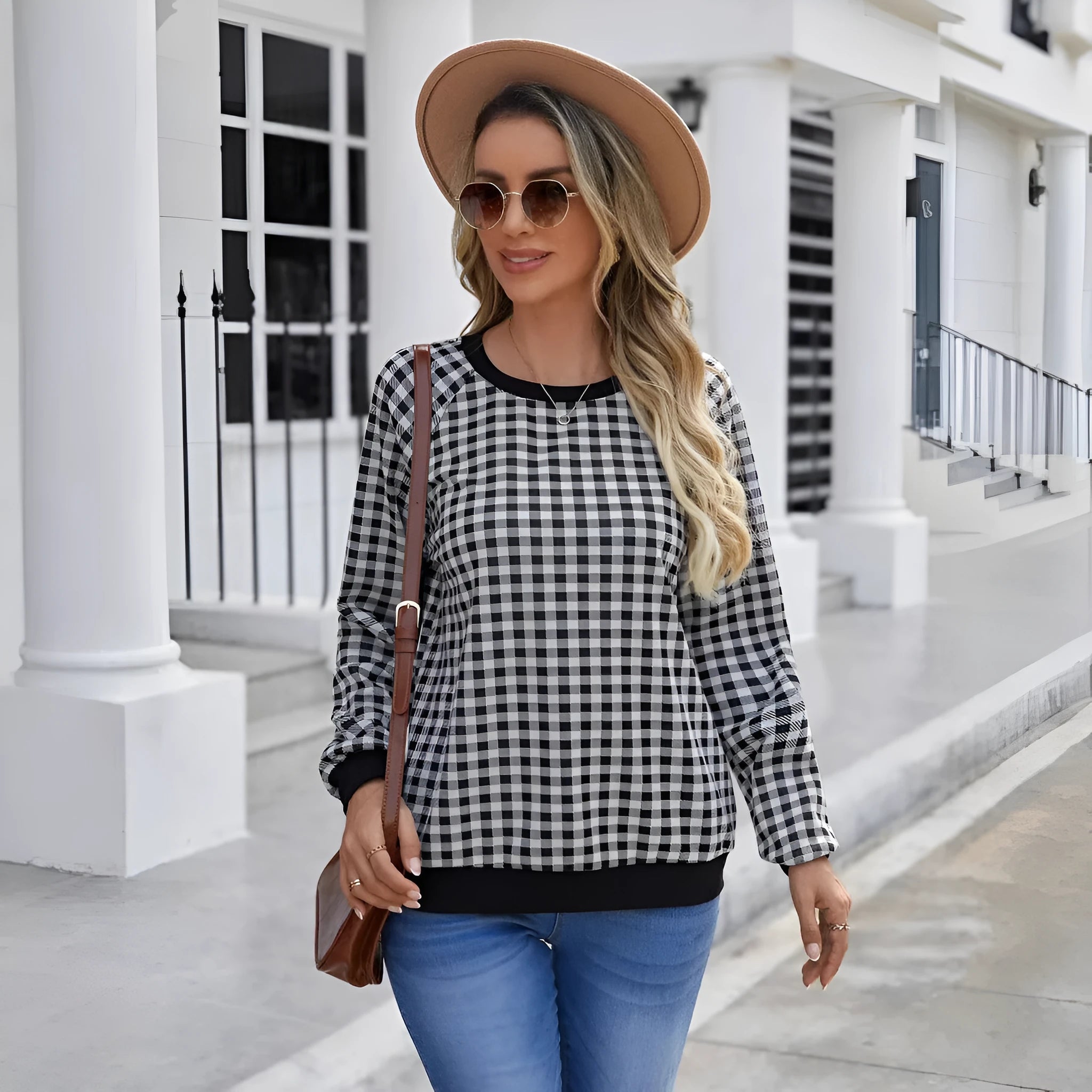 Black and white plaid print long sleeve pullover sweater for men on a neutral background.