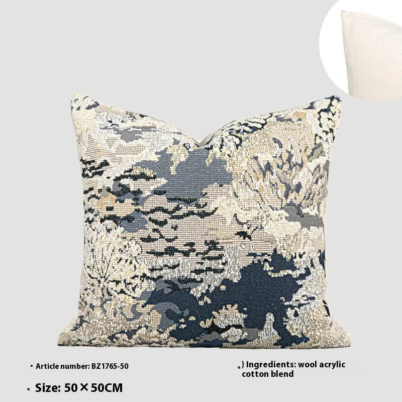Antique blue decorative pillow with abstract floral pattern, wool blend fabric, on a sofa.