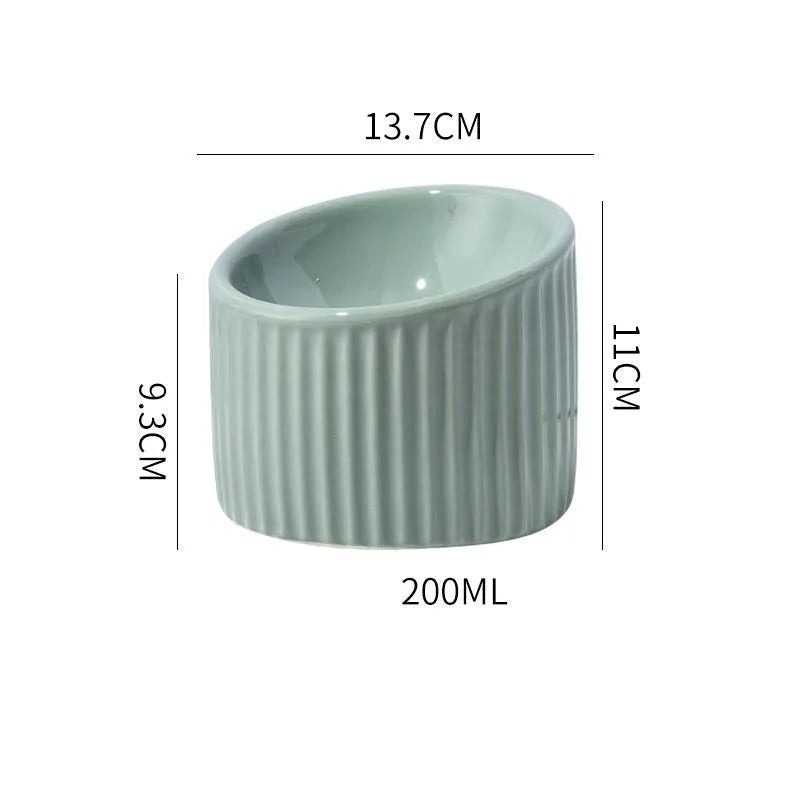 Dark green ceramic elevated cat bowl with tilted design on a raised platform.