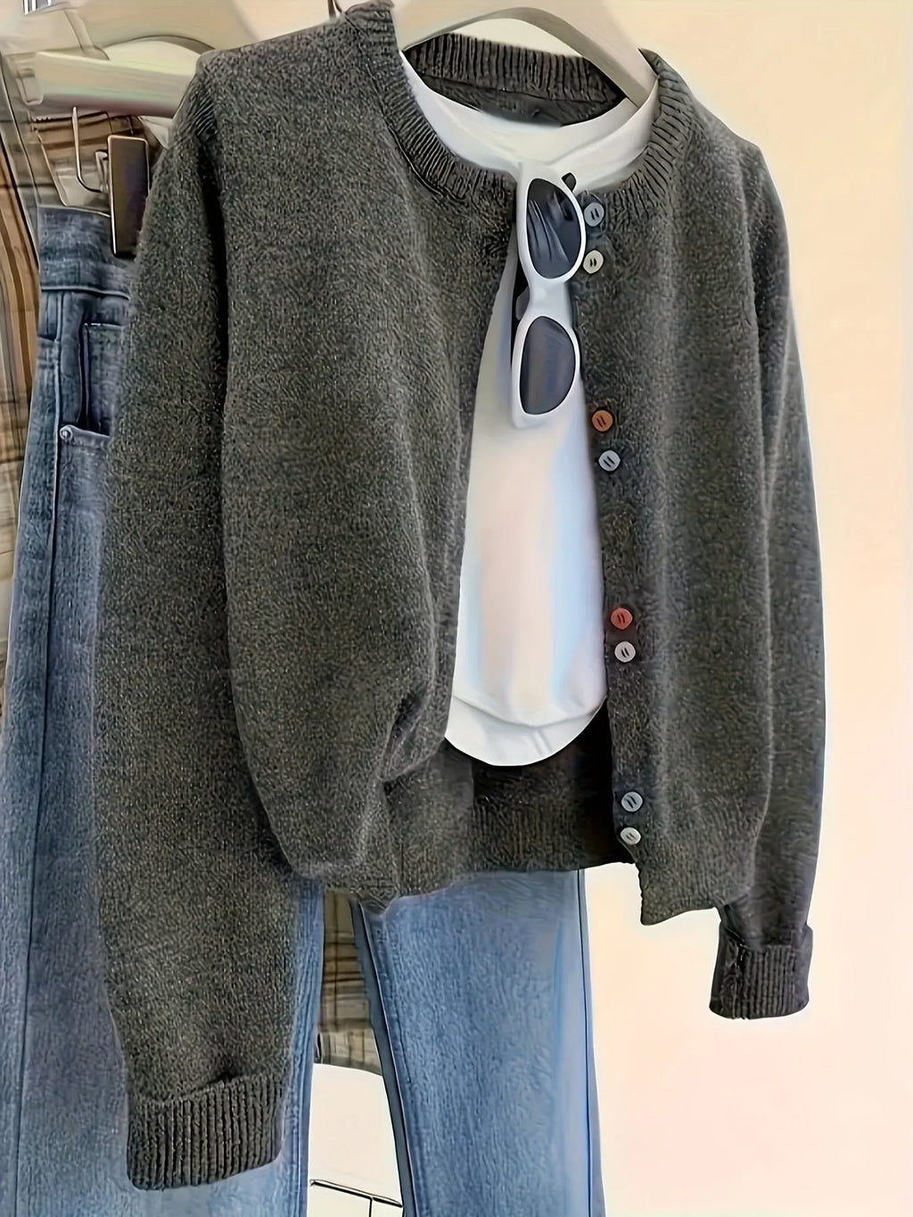 Women's dark grey button-front polyester cardigan sweater on a hanger.