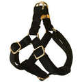 Black flannel dog harness with gold buckle on a light background, showing chest strap and leash