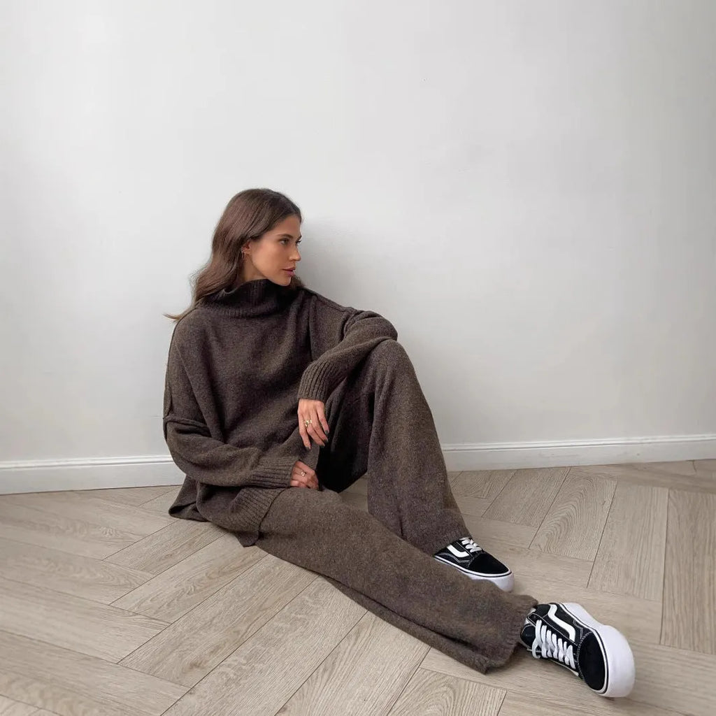 Dark grey women's knitted side-slit top and matching trousers set on a hanger