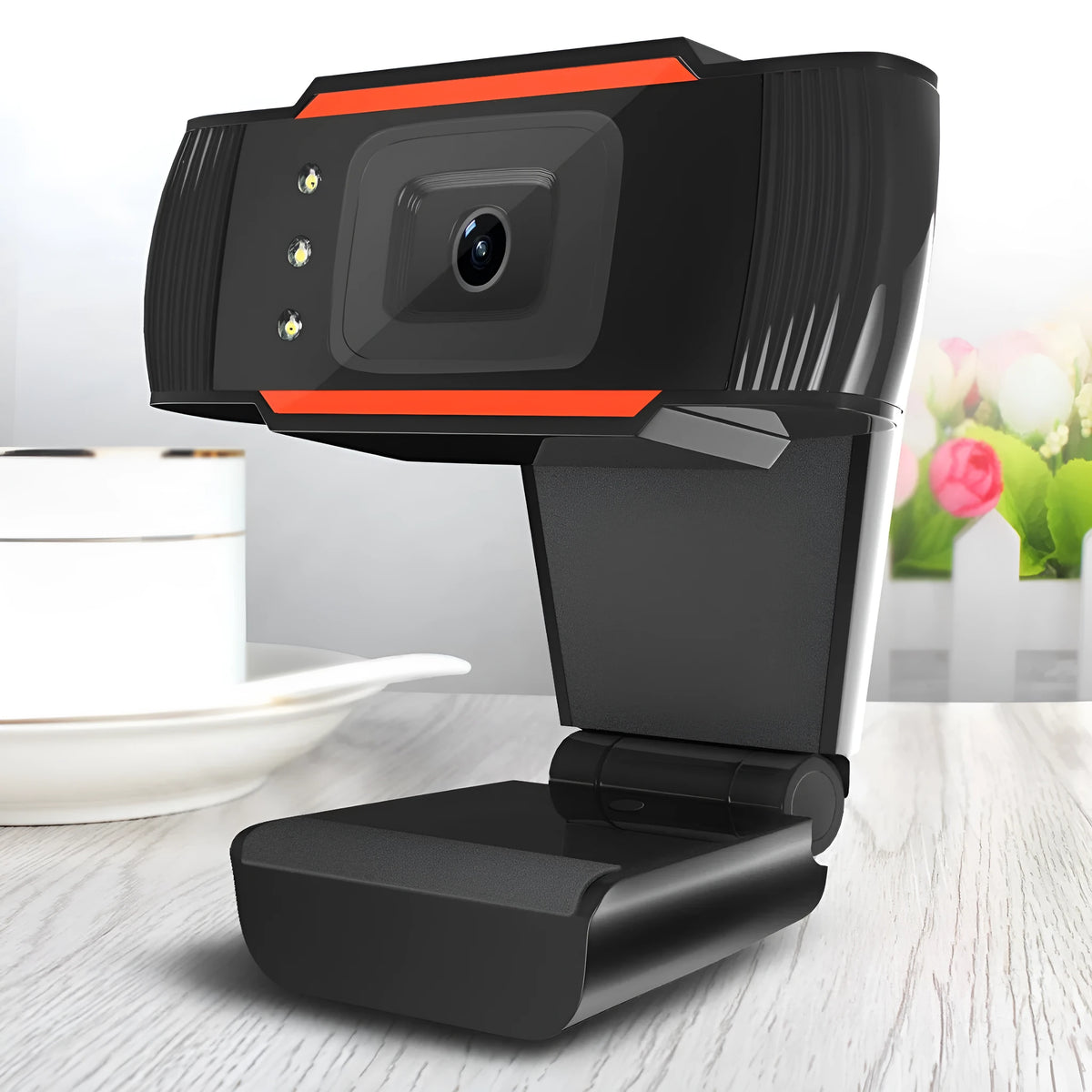 Black USB webcam with LED fill light on a desktop computer, showing built-in light ring and compact ABS housing