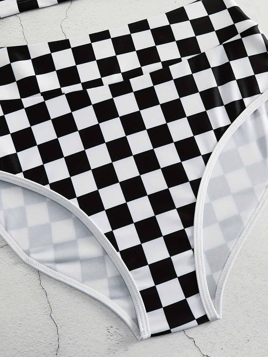 Women's black and white checkerboard racing one-piece swimsuit with backless design and suspender straps