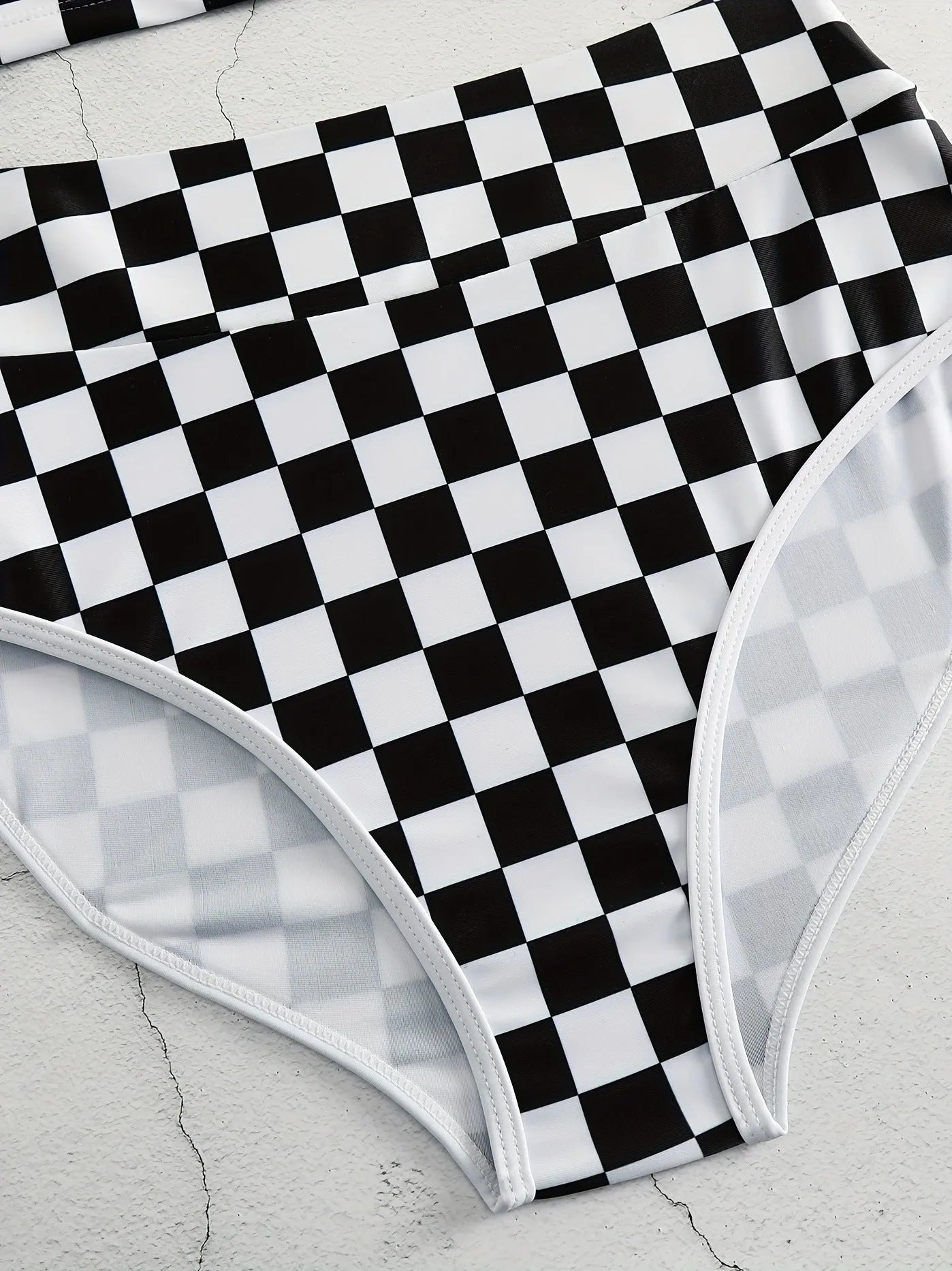 Women's black and white checkerboard racing one-piece swimsuit with backless design and suspender straps