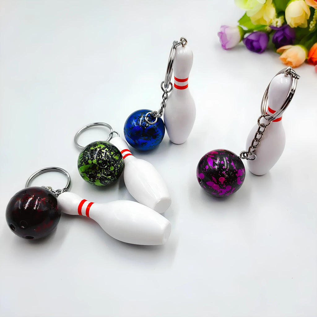 Mini bowling ball keychain in four colour options: dark red, blue, purple, green
