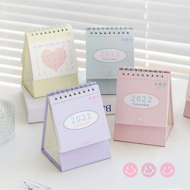 2022 paper desk calendar with coil binding, Regular or Professional size, in green, pink, purple, or yellow.