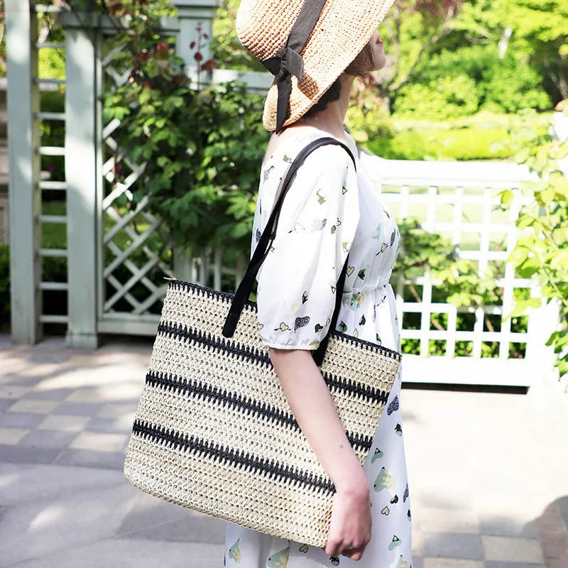 Large striped straw woven handbag with 64cm shoulder strap and polyester lining, shown in khaki or black