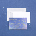 Set of three bronzing mermaid-style folded greeting card envelopes in celestial colourways, 13x8.5cm, on a light background
