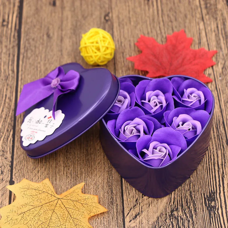 Heart-shaped tin box containing handmade soap flowers and a bear accent in a romantic gift arrangement