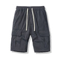 Man wearing loose, multi-pocket cropped pants in brick red for outdoor summer leisure.