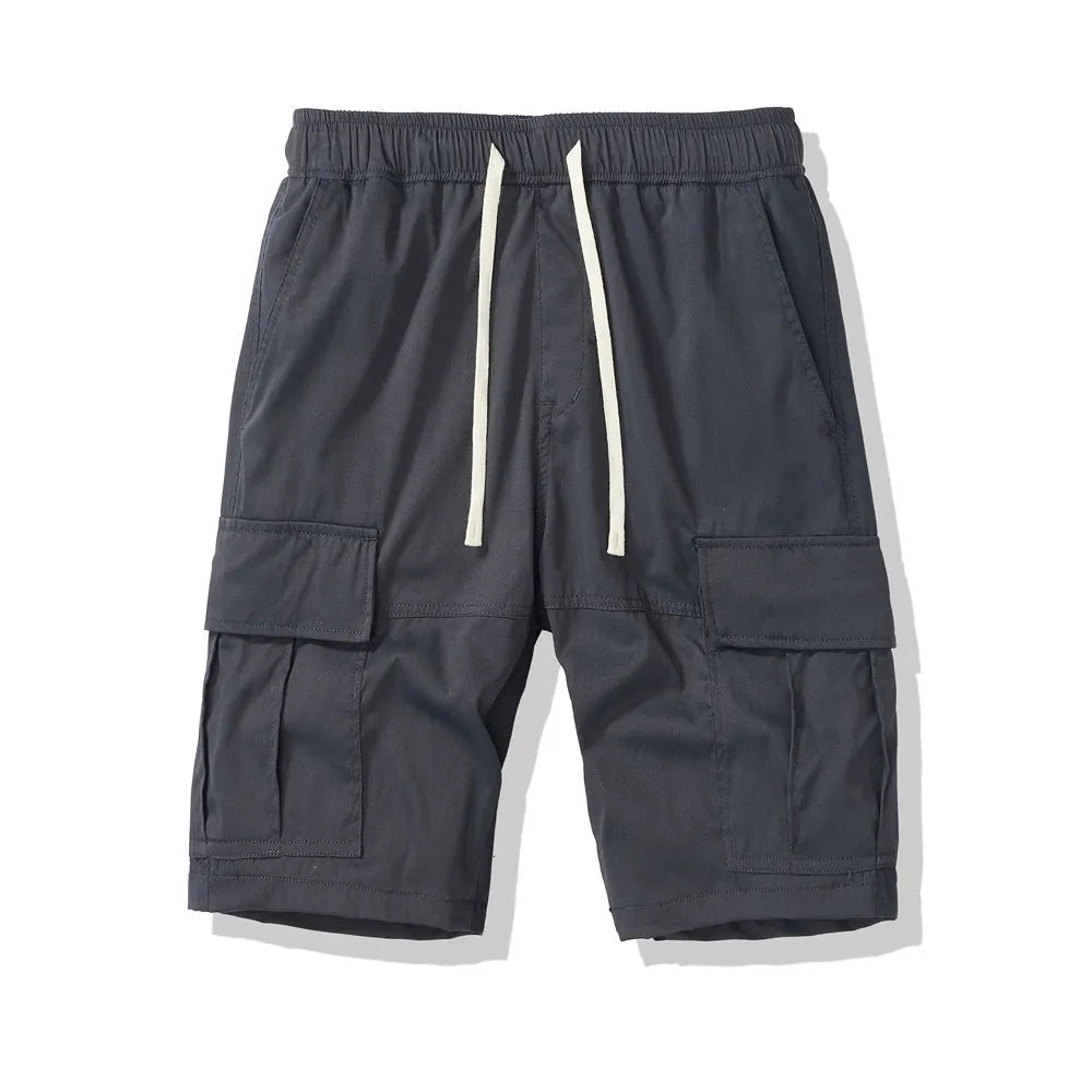 Man wearing loose, multi-pocket cropped pants in brick red for outdoor summer leisure.