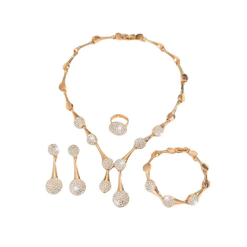 Gold alloy necklace earrings and bracelet set with bow and fan motifs on a light background