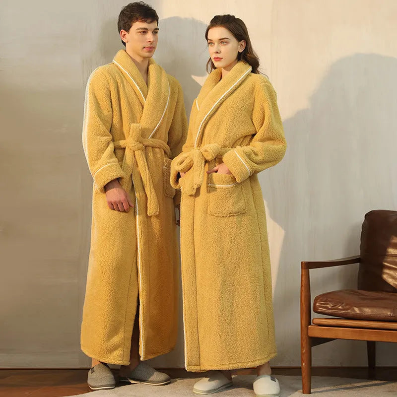 A man and woman wearing matching thick navy blue flannel nightgown robes in a winter home setting.