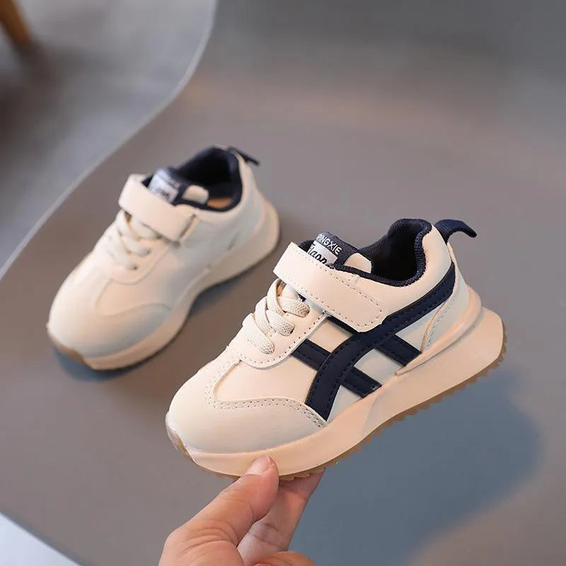 Children's white casual sneaker with Velcro strap and rubber sole, shown in sizes 21-30.