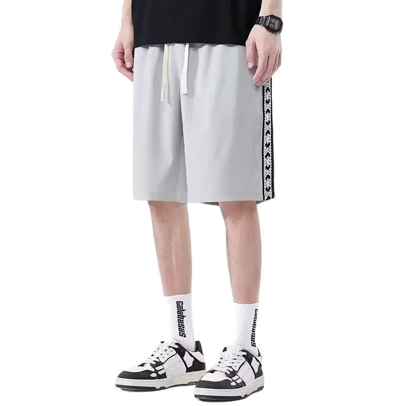 Man wearing loose-fit black track pants, showcasing the baggy sports style and elastic waist.