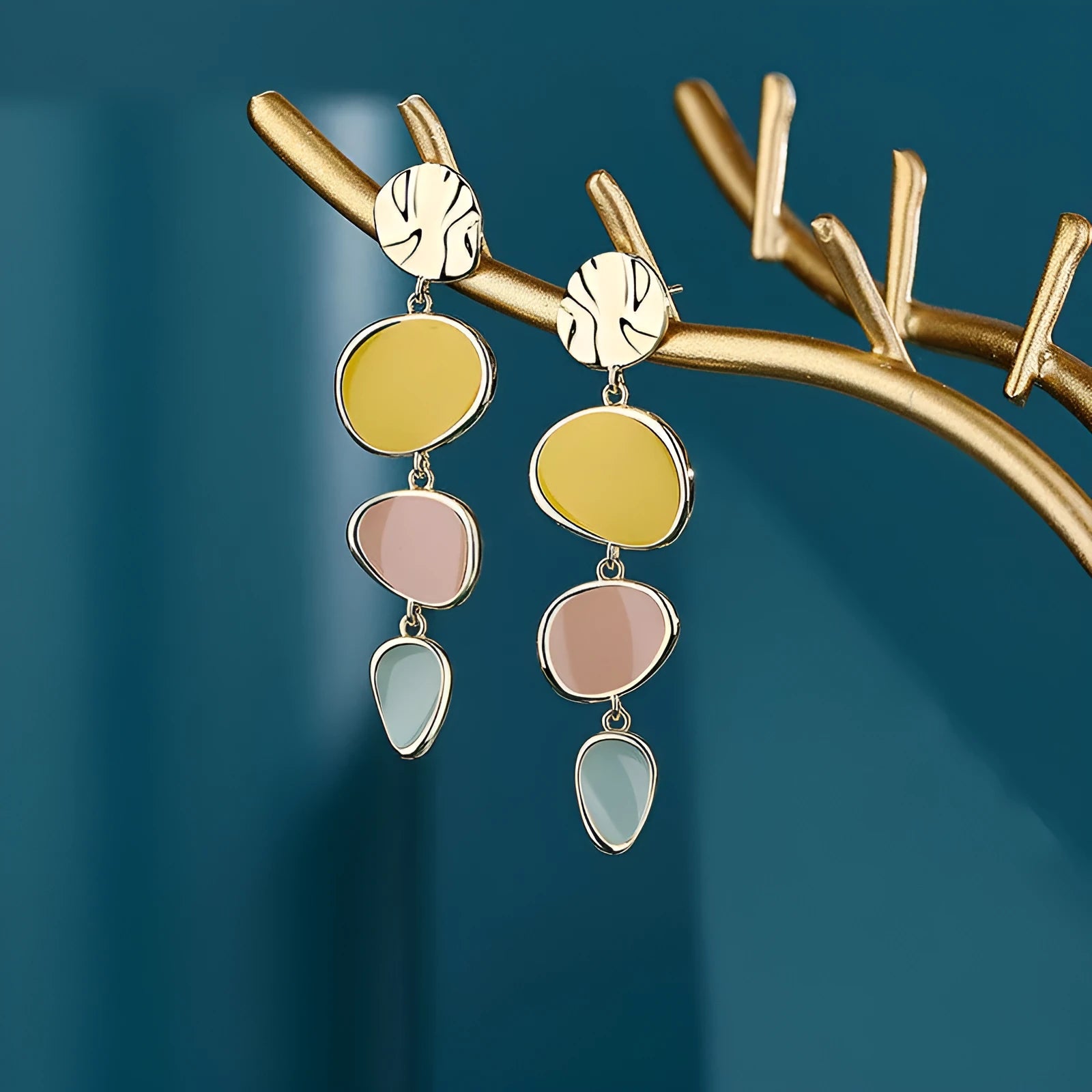 A pair of simple disc-shaped earrings with a morandi three-colour oil-drip finish and sterling silver posts.