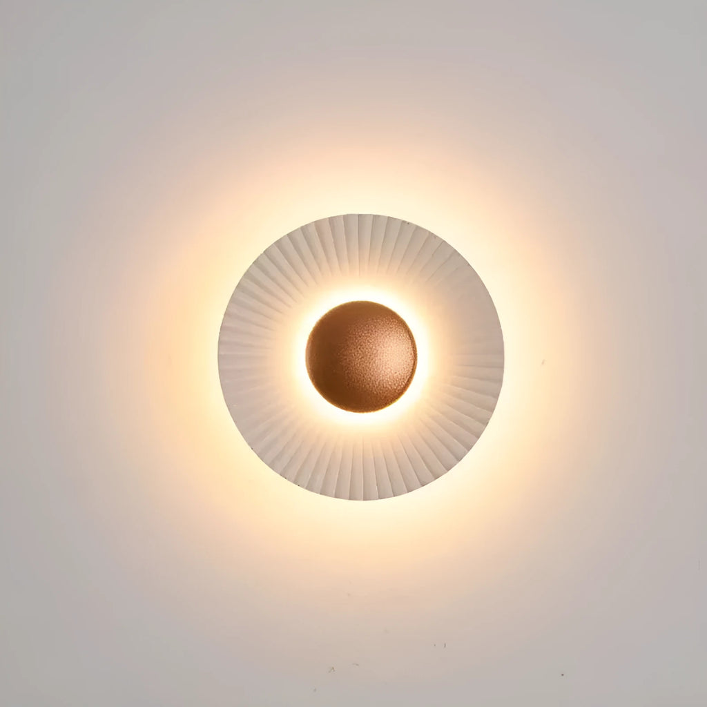 Round aluminium wall lamp in an outer white and inner gold colour combination, mounted on a wall.