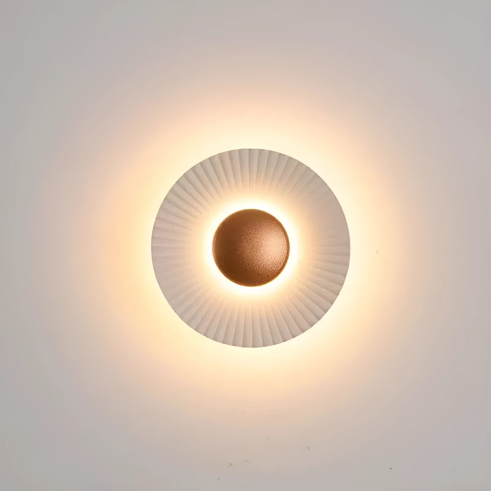Round aluminium wall lamp in an outer white and inner gold colour combination, mounted on a wall.