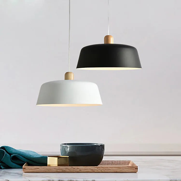 Nordic round zinc alloy pendant light in black with adjustable suspension height over a wooden dining table
