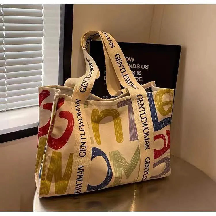 Large women's canvas tote bag with printed design, shown in available colour options.
