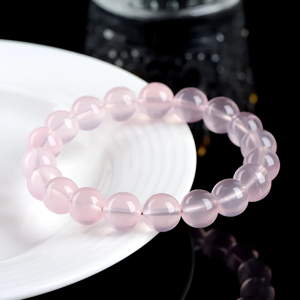Natural pink starlight crystal round bead bracelet with polished 10mm stones on elastic cord
