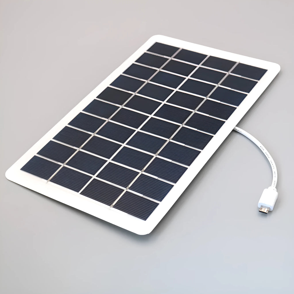 Black portable solar panel charger with USB port for mobile phones on a textured surface.