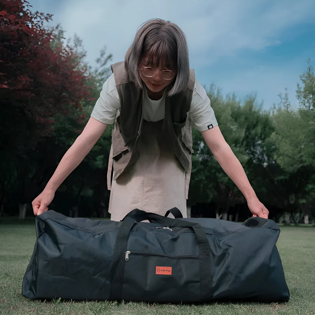 Green and grey waterproof storage bag for camping tents and folding chairs, shown with gear inside and folded compactly.