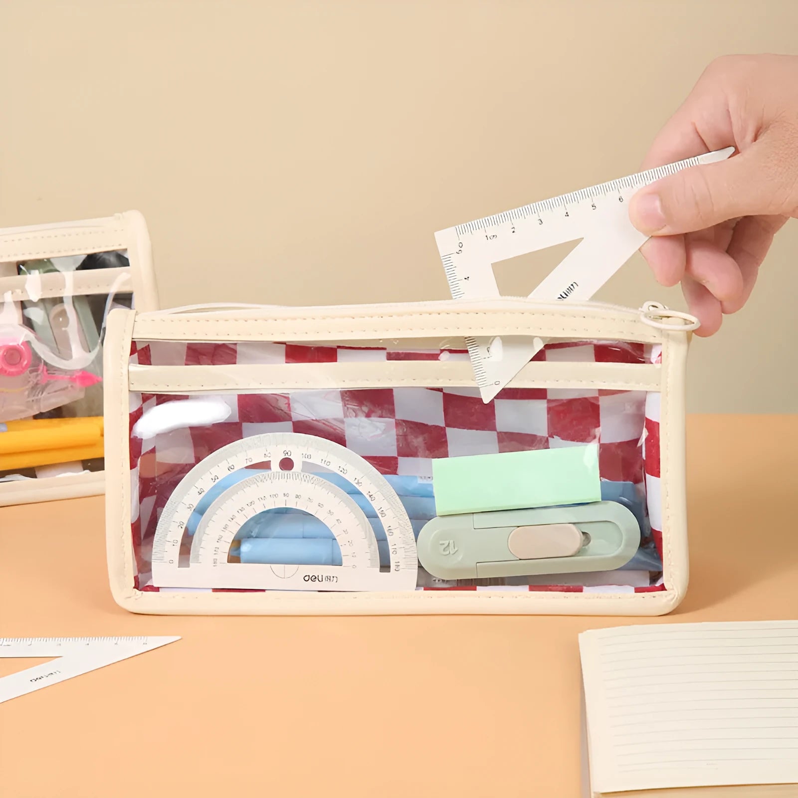 Large transparent PVC pencil case with internal black and white chessboard grid design.