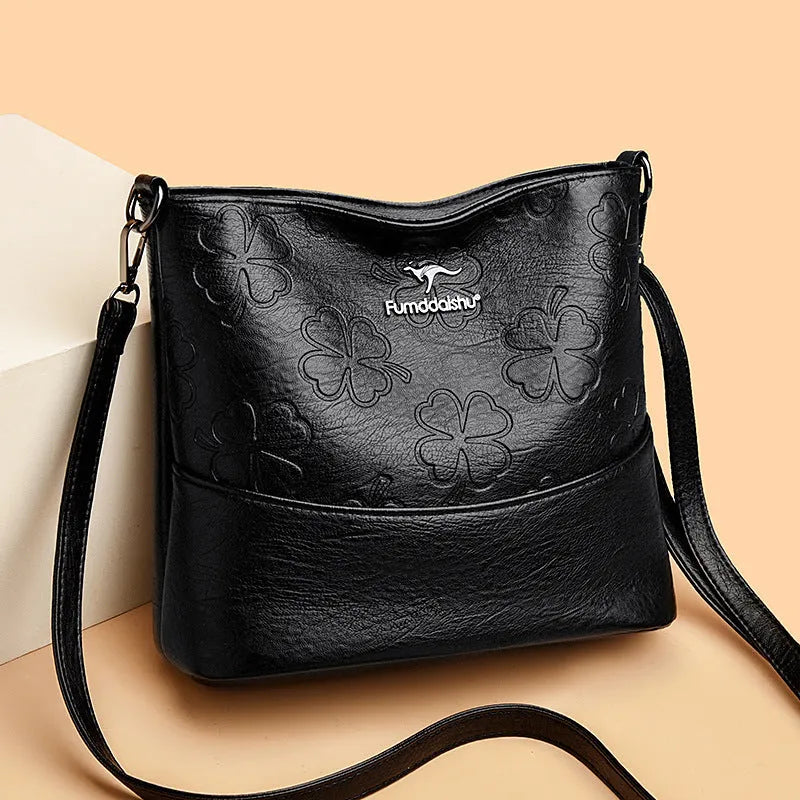 Soft PU leather bucket bag with embossed flower pattern and stitching details in black