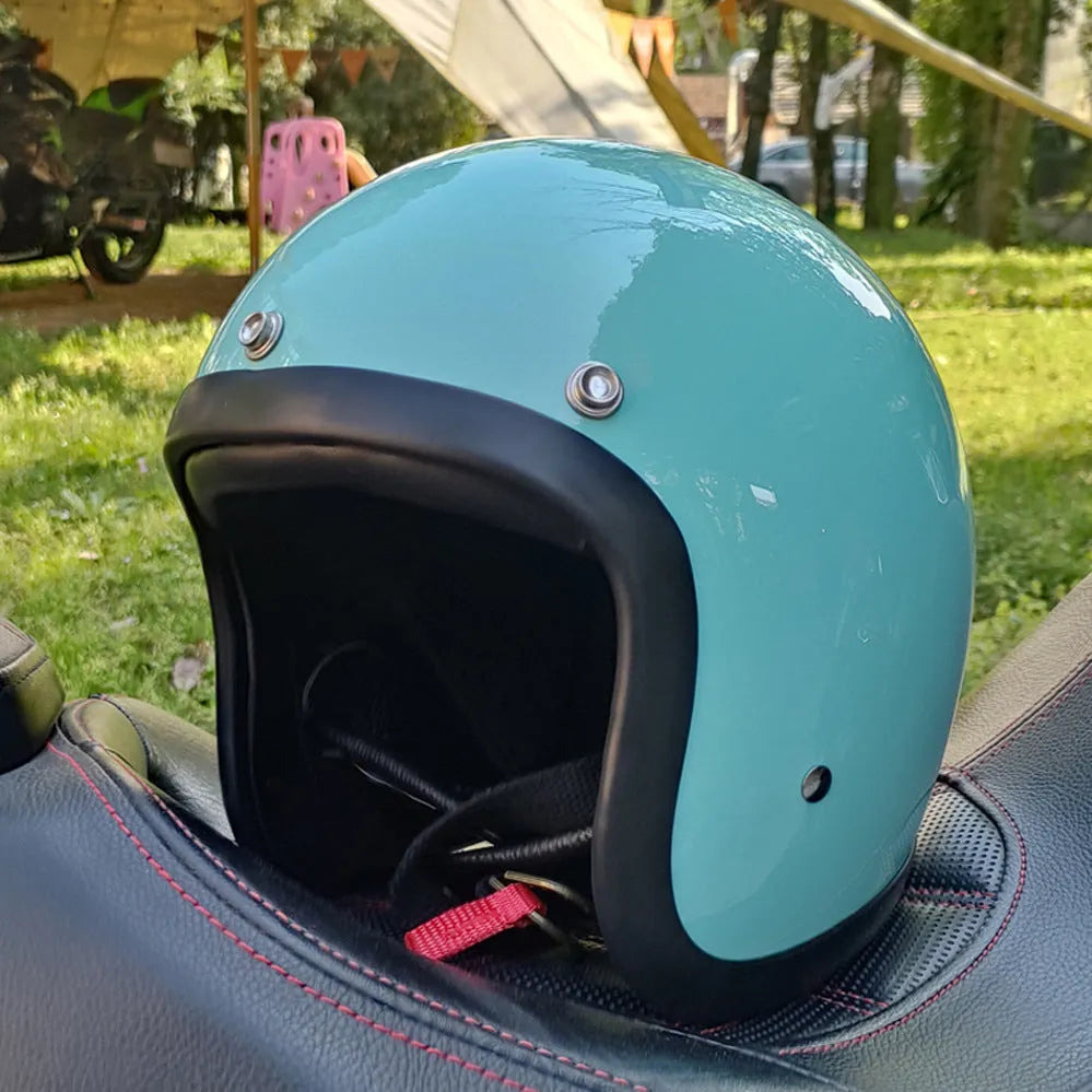 Retro-style open-face motorcycle helmet in matte black with floral design, showing clear visor and interior padding.