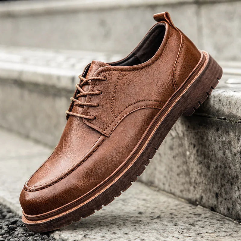 Brown low-top casual leather shoes with round toe and flat rubber sole on a white background.