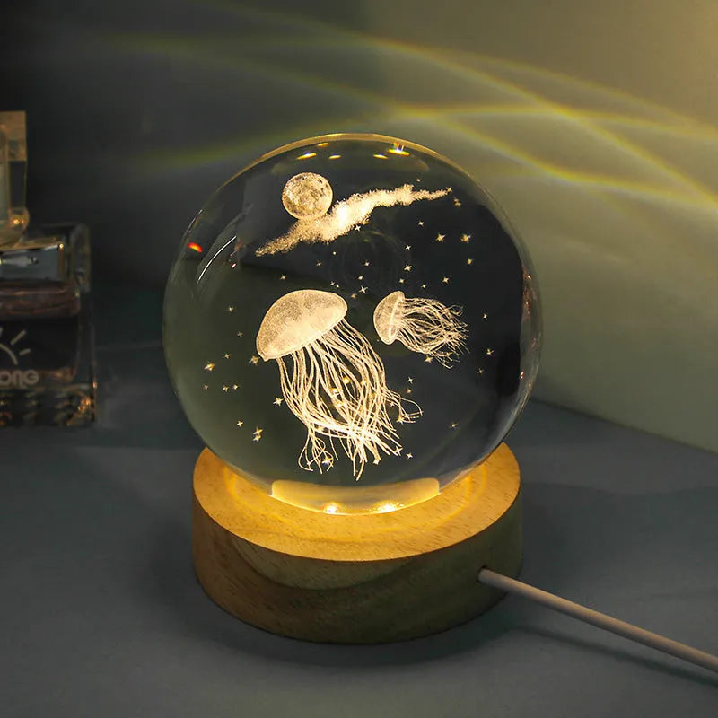 Transparent crystal ball night lamp with 3D carved jellyfish design, on a round base with USB cable.