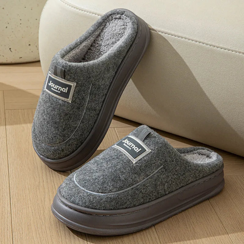 Men's brown and grey suede slippers with a thick sole on a plain background