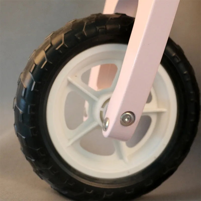 Pink wooden balance scooter for toddlers with a 10-inch non-slip deck.