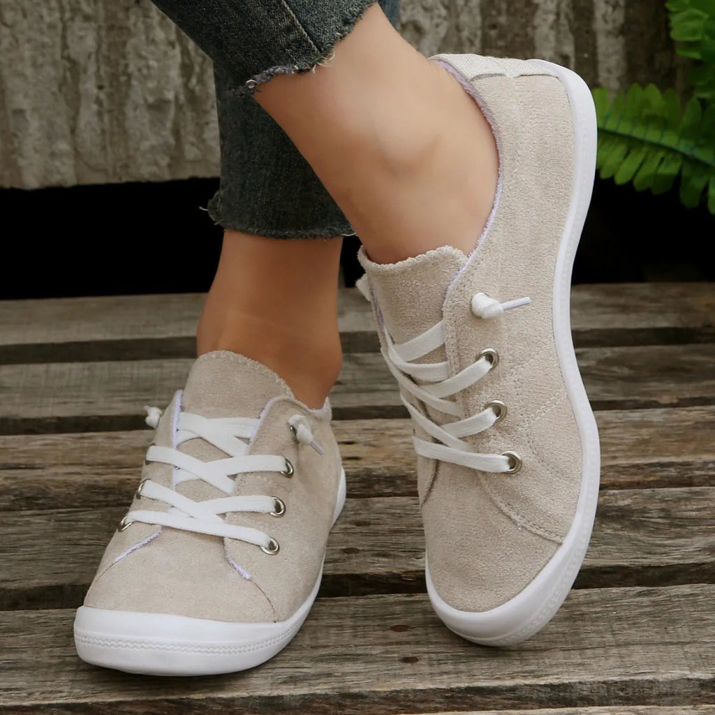 Women's creamy white casual low-top sneakers with fabric upper and rubber sole on a neutral background.