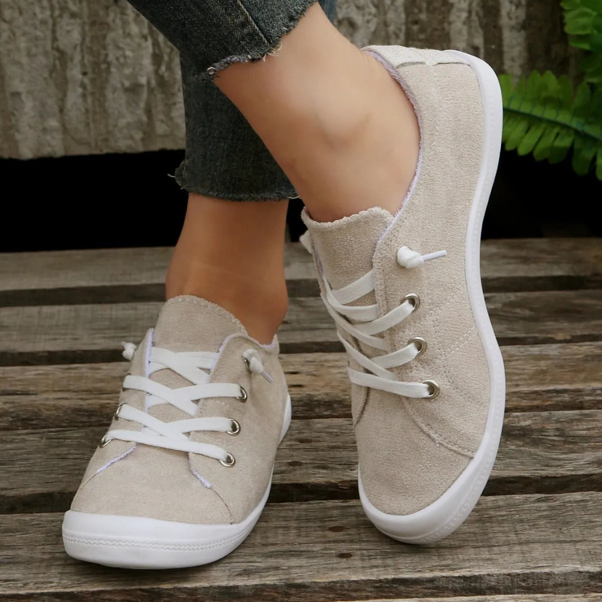 Women's creamy white casual low-top sneakers with fabric upper and rubber sole on a neutral background.