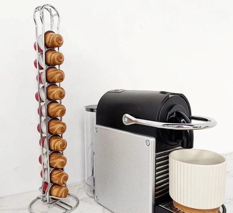 Black and silver wrought iron coffee capsule storage rack holding pods on shelves.